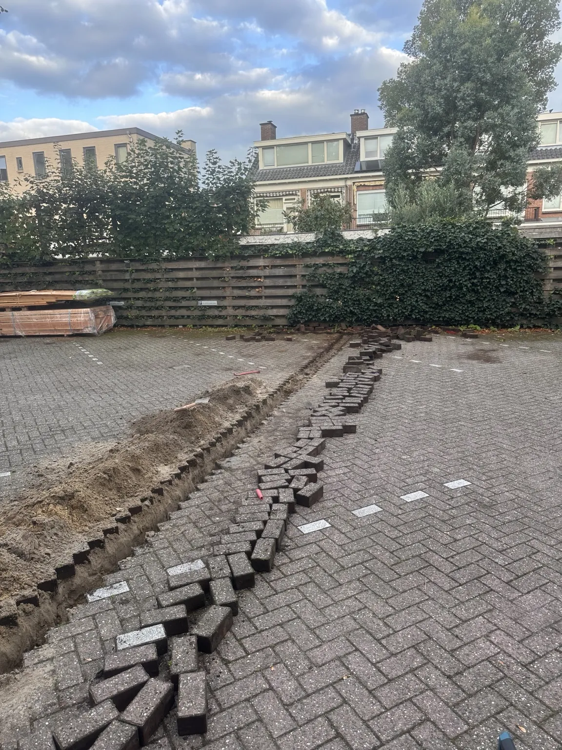 Opengebroken klinkerbestrating met sleuf voor het kabeltracé