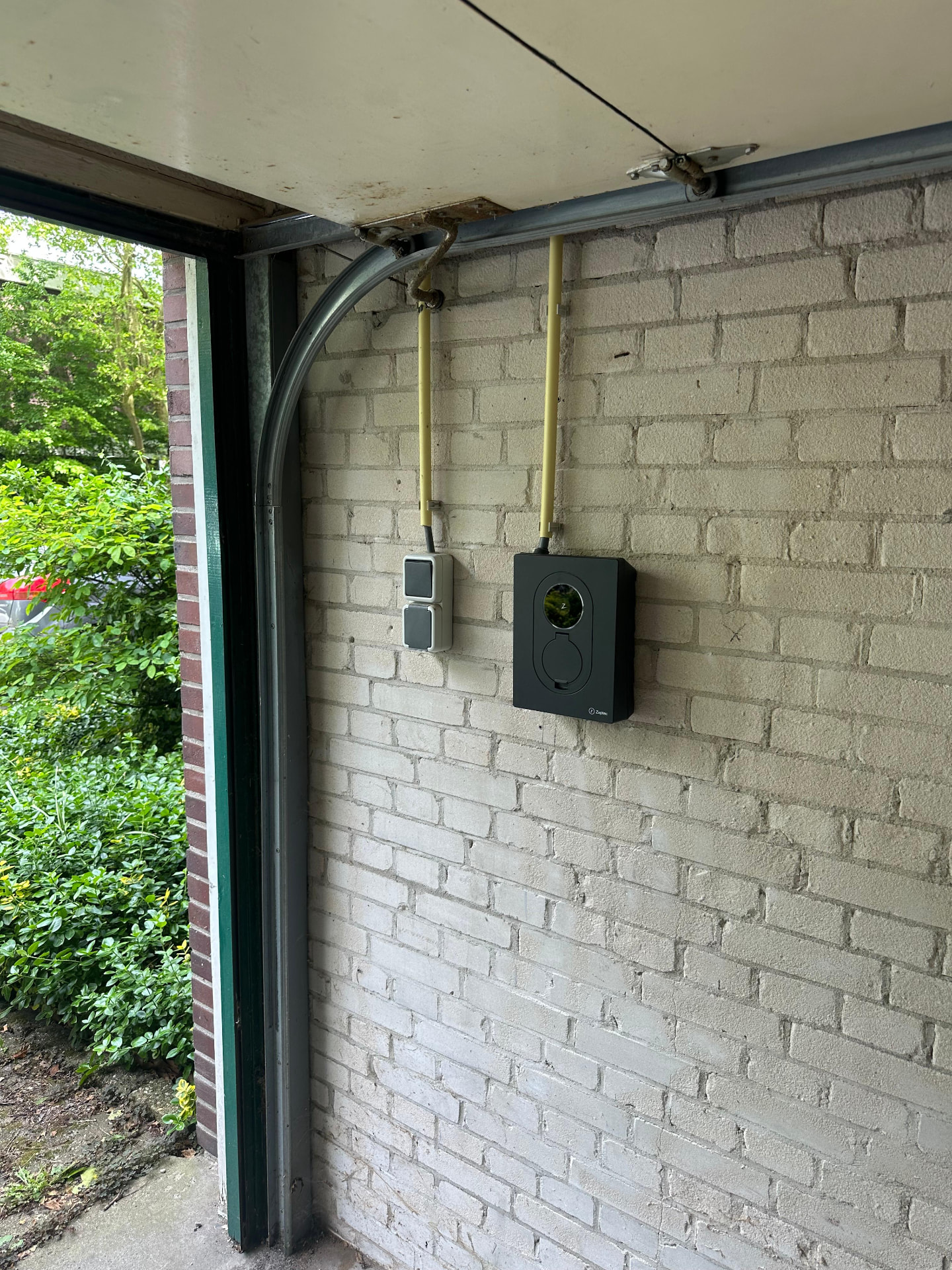 Laadpunt bij een oprit met afgeschermde kabelinvoer naar de meterkast