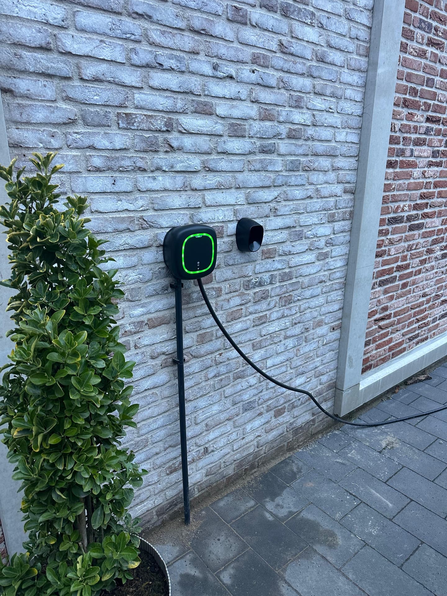 Wandlaadpunt aan de gevel naast de voordeur van een woning
